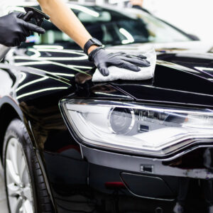 a man cleaning car with cloth, car detailing (or valeting) concept. selective focus.